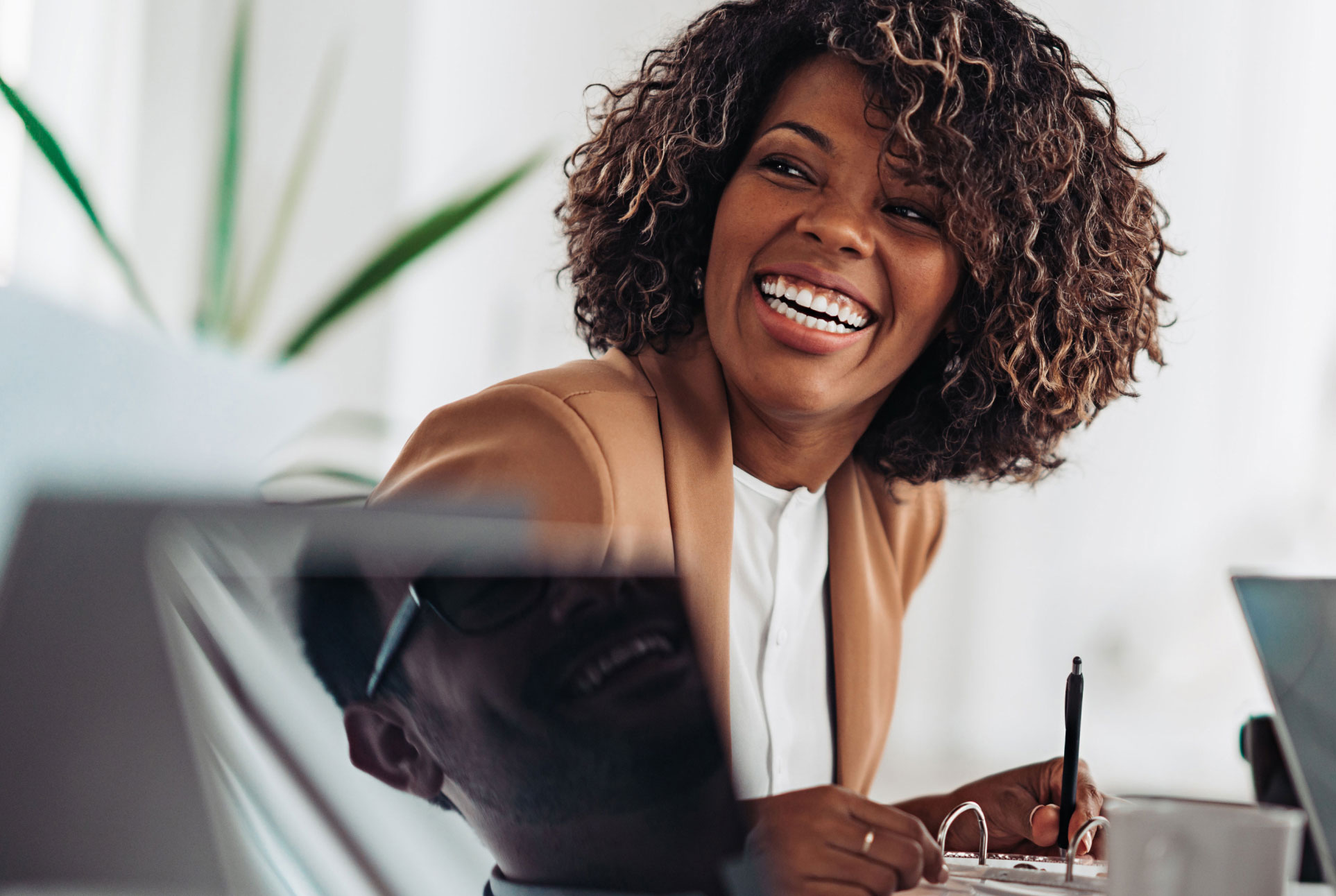 Woman smiling A woman smiles while writing on paper.