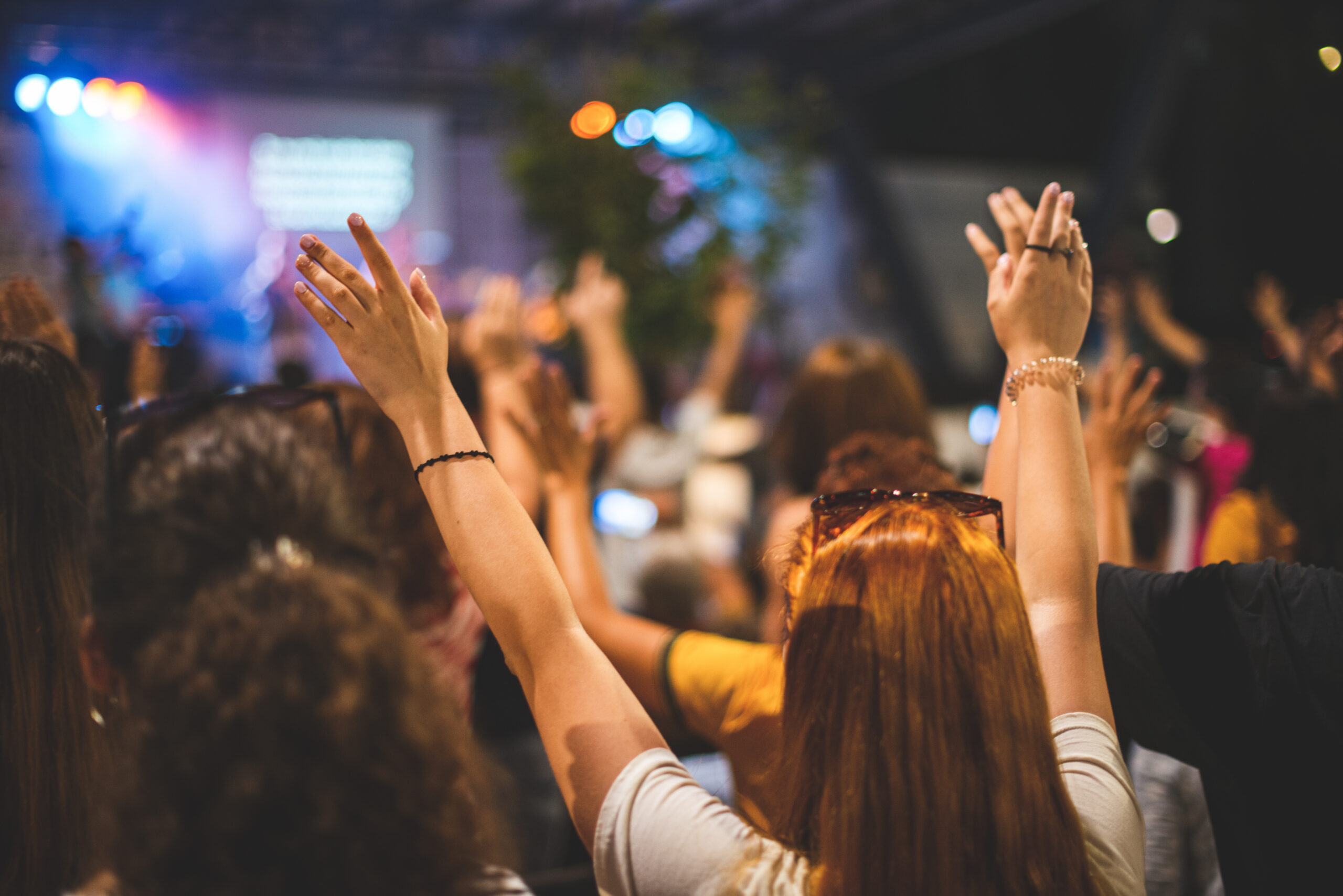 A group of people raising their hands in the air.